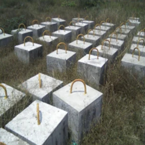 Rows of concrete sinker blocks, cast and staged in the yard